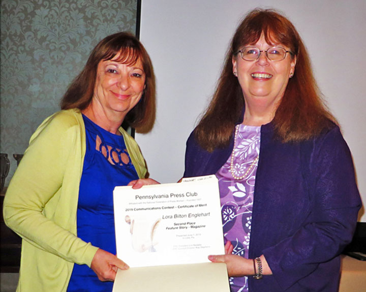 Contest director Kay Stephens, right, presents an award for a magazine feature story to Lora Englehart at the June 1, 2019 PPC Awards Luncheon.